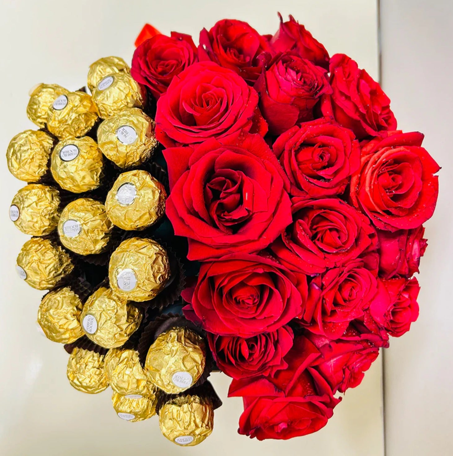 Round-shaped luxury gift arrangement with fresh red roses and Ferrero Rocher chocolates, perfect for romantic gifting on Valentine's Day, anniversaries, and special celebrations."